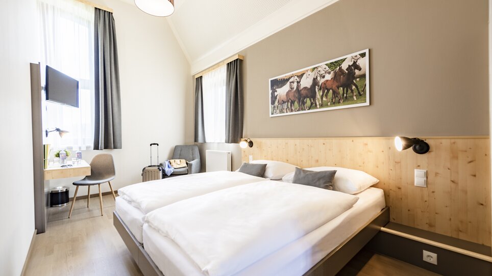 Double room at JUFA Hotel Maria Lankowitz featuring the bed. | © LenzJUFA Hotels