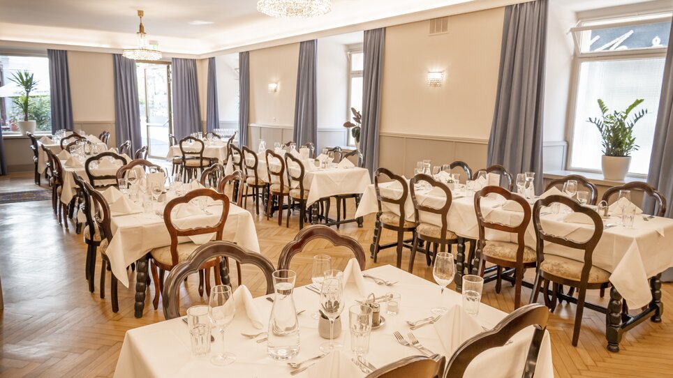 Ein stilvolles Restaurant im Hotel Mariahilf mit aufgedeckten Tischen und Holzsesseln mit geschwungener Rückenlehne. | © Hotel Mariahilf