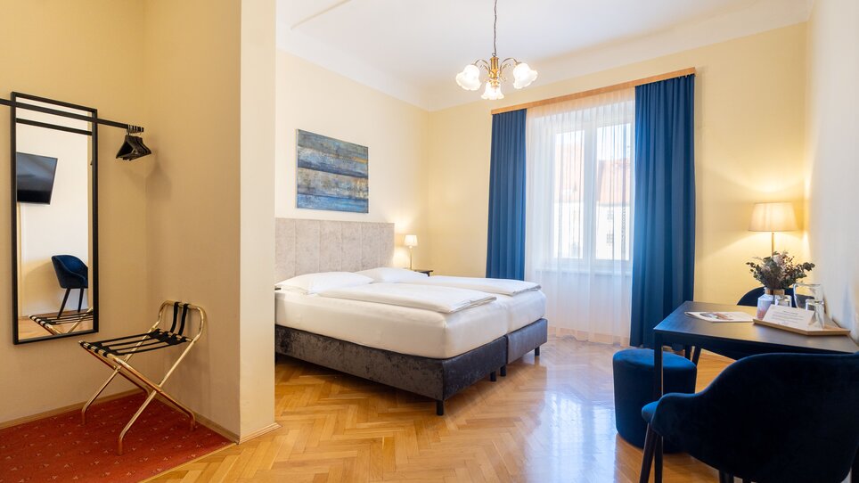 Modernes Gästezimmer mit Doppelbett, Tisch und TV, ideal für Geschäftsreisende im Hotel Mariahilf. | © Hotel Mariahilf