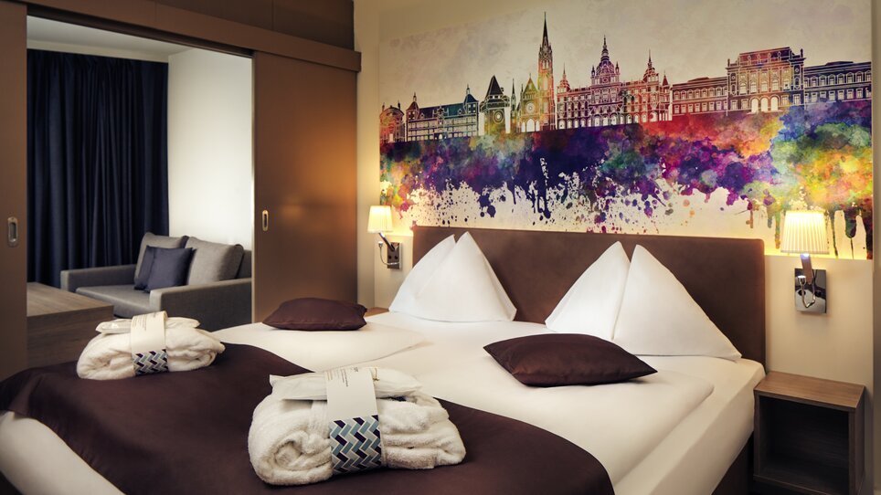 Ein modernes Doppelzimmer mit einem bunten Stadtbild von Graz im Hotel Mercure Graz City. | © Mercure Graz City - Abaca Corporate - Mitja Kobel