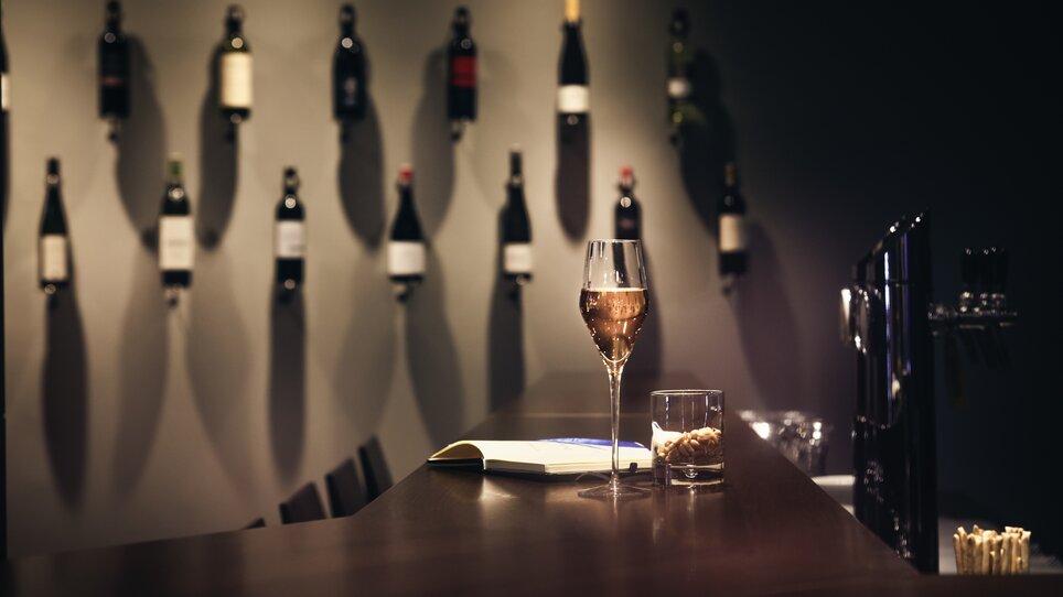 Ein Glas Sekt, ein Whiskyglas mit Snacks und ein Buch auf der Bar des Hotel Mercure Graz City. | © Mercure City - Abaca Corporate - Mitja Kobel