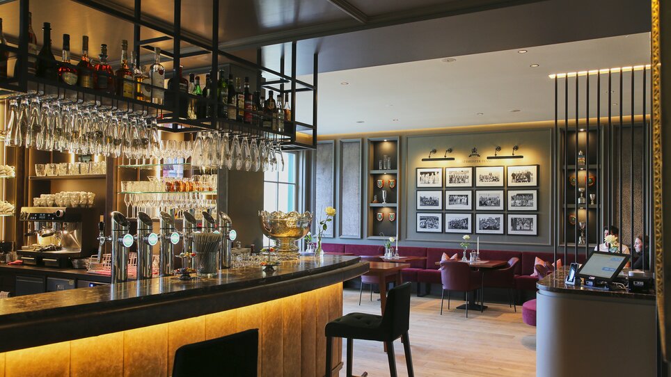 Elegante Bar mit Glasregal, stilvollen Möbeln und modernen Elementen im Murhof Hotel & Restaurant. | © Murhof