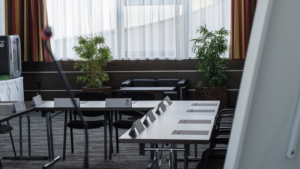 Einblick in einen eleganten Tagungsraum mit Tisch, Stühlen und Pflanzen im PLAZA INN Graz City. | © PLAZA INN Graz City