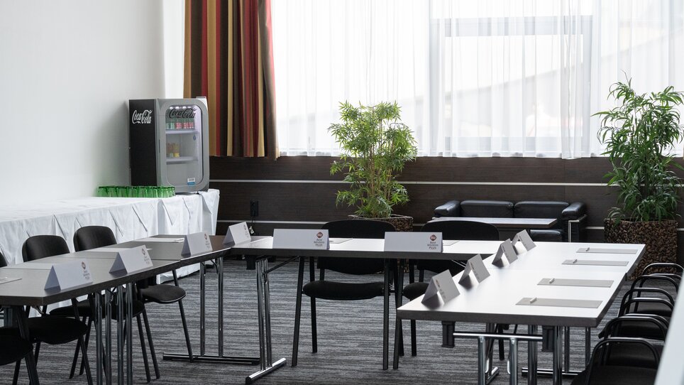 Einblick in einen stilvollen Tagungsraum mit Pflanzen und einem Kühlschrank für Erfrischungen im PLAZA INN Graz Cityz. | © PLAZA INN Graz City