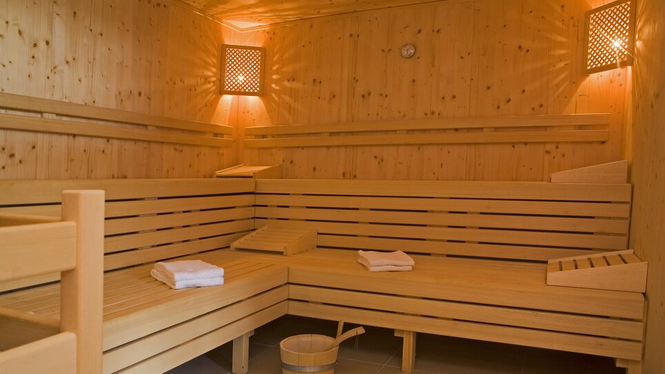 Innenansicht einer modernen Sauna mit Holzbank und Handtüchern im PLAZA INN Graz City. | © PLAZA INN Graz City