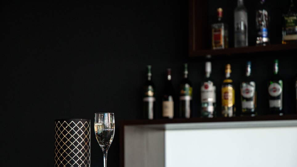 Ein Glas und eine Visitenkarte vor einer Bar, ideal für Networking im PLAZA INN Graz City. | © PLAZA INN Graz City - Elena Brandau