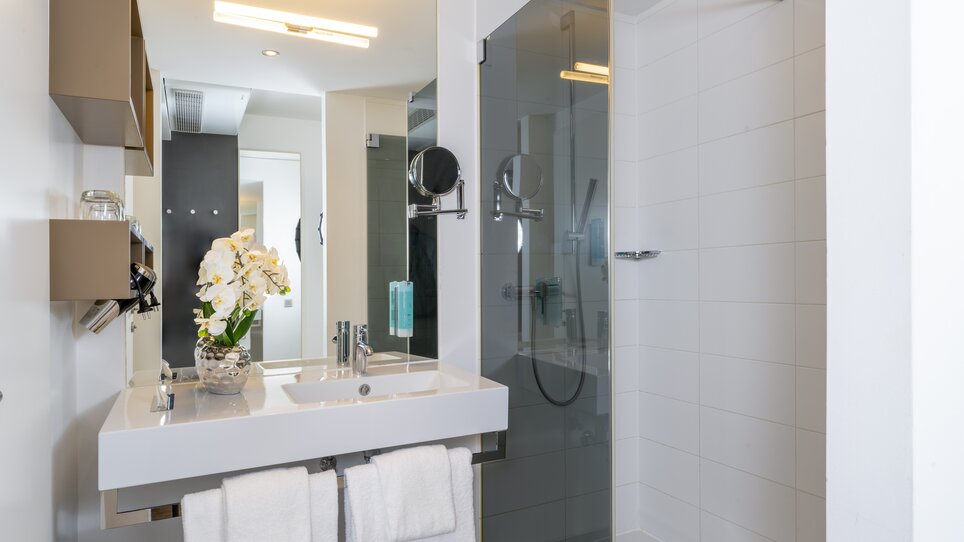 Helles Badezimmer im PLAZA INN Graz Messe mit Waschbecken und Dusche. | © PLAZA INN Graz Messe