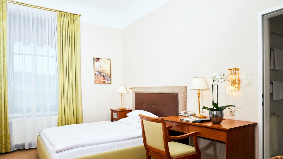 View of a room in the Parkhotel Graz featuring a desk and bed. | © Parkhotel Graz