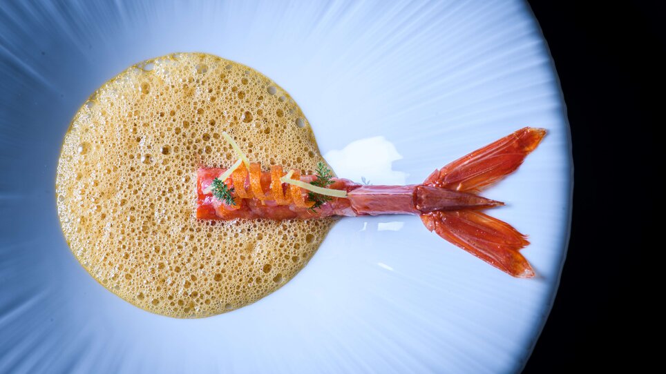 Ein kunstvoll angerichtetes Garnelen-Gericht mit Schaum und Dekoration serviert im Royal Dining Restaurant Zur Goldenen Birn. | © Philipp Lihotzky