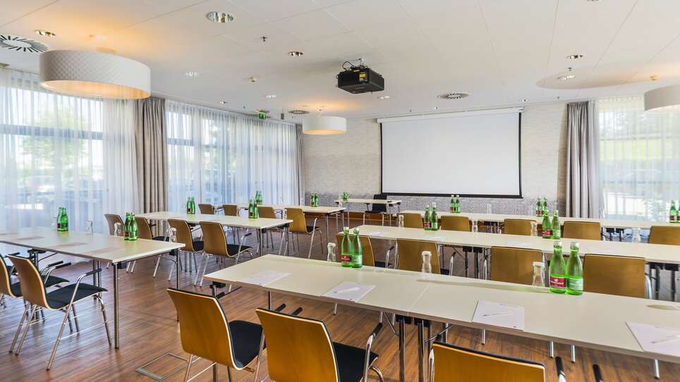 Moderner Konferenzraum für Tagungen und Meetings im Hotel Ramada Graz, ausgestattet mit Projektor und Wasserflaschen. | © Hotel Ramada Graz