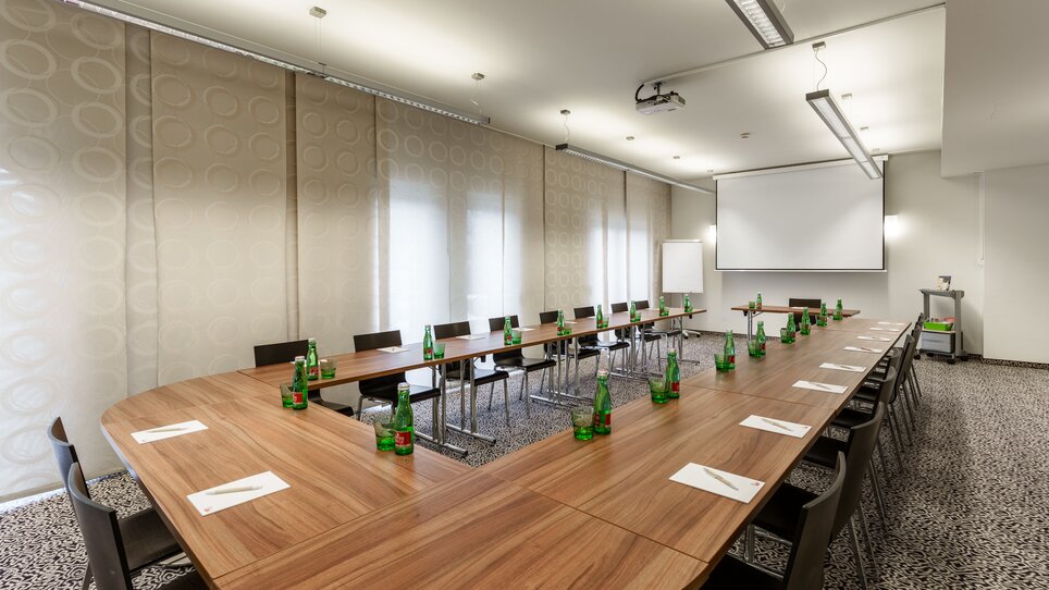 Meeting room in Hotel Süd featuring table, chairs, and water bottles. | © Hotel Süd