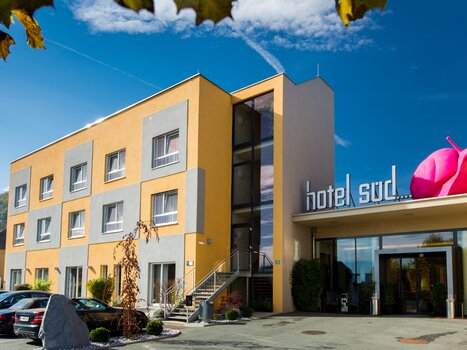 Außenansicht des Hotel Süd mit pinkfarbener Schnecke und Unterstützung für Businessreisen. | © Hotel Süd Art