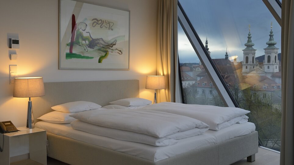 Blick auf das Schlafzimmer im Schlossberghotel mit Aussicht auf Graz und den Grazer Uhrturm. | © Schlossberghotel