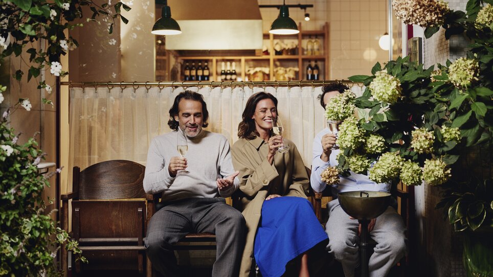 Drei Personen toasten mit Getränken im Hotel Weitzer, umgeben von Pflanzen. | © Florian Weitzer Hotels & Restaurants (6) - Kopie