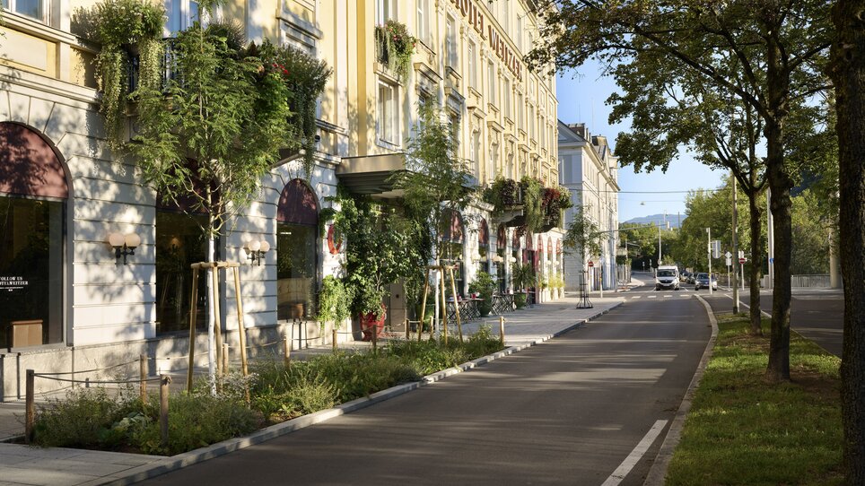 View of Hotel Das Weitzer in Graz, framed by trees and the Mur river. | © Florian Weitzer Hotels & Restaurants