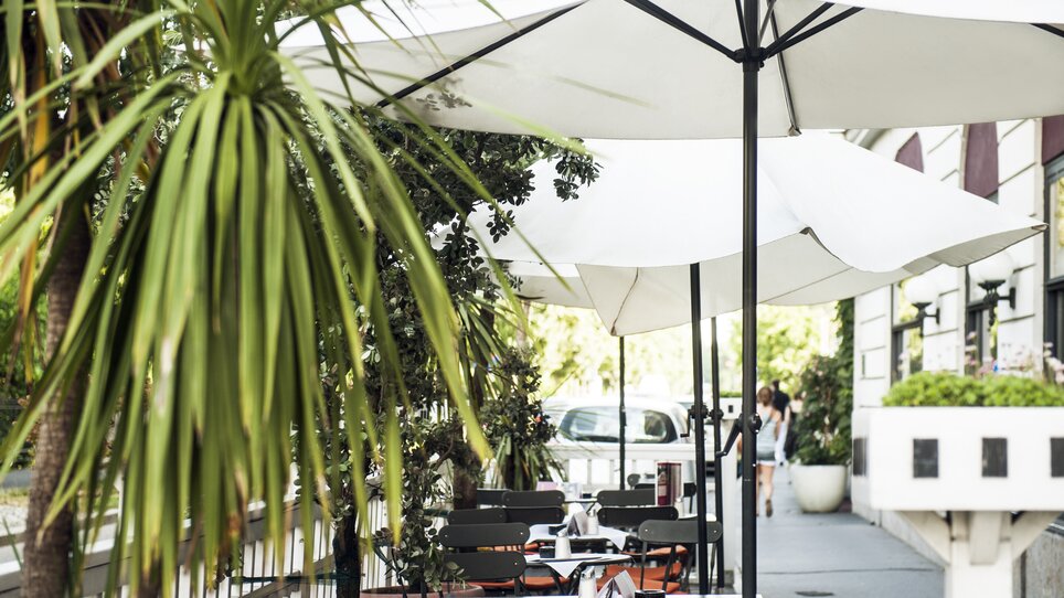 Outdoor area of Hotel Das Weitzer with tables and umbrellas. | © Florian Weitzer Hotels & Restaurants