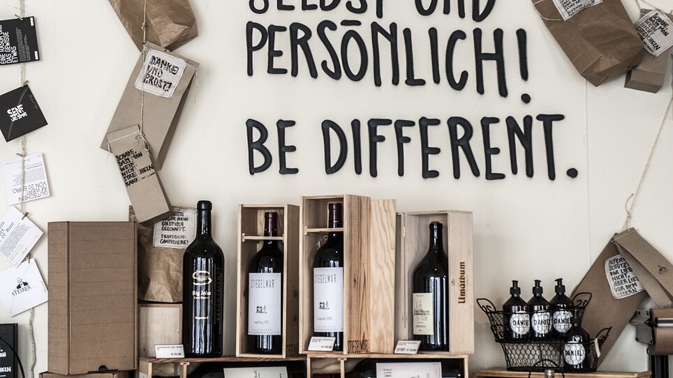 Wall design with slogans and wooden shelves in the store at Hotel Das Weitzer. | © Florian Weitzer Hotels & Restaurants