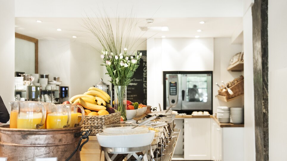 A breakfast buffet at Hotel Das Weitzer featuring fruits, juices, and modern equipment. | © Florian Weitzer Hotels & Restaurants