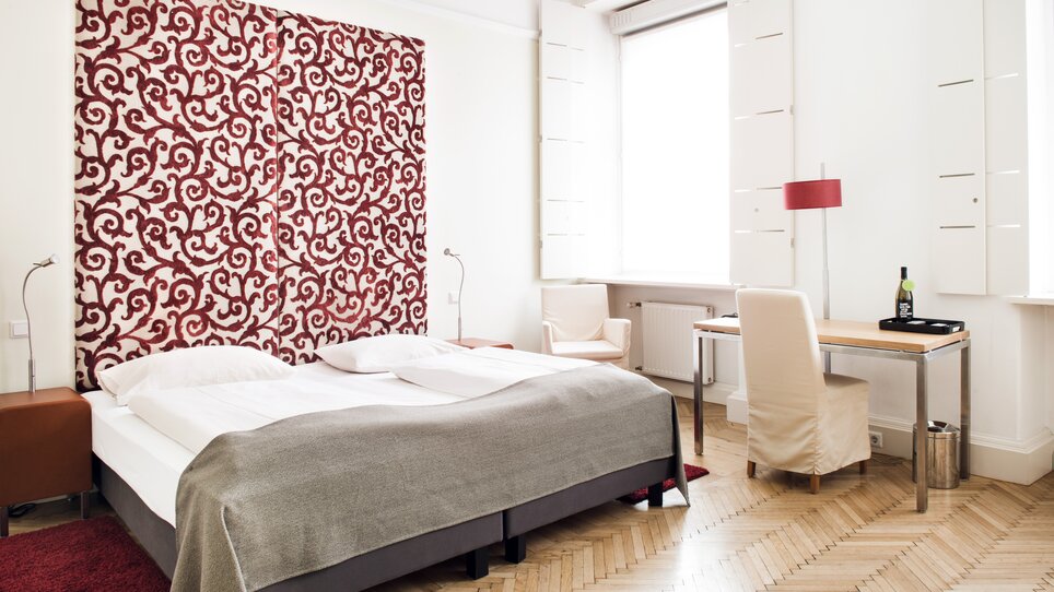 Ein Hotelzimmer im Hotel Weitzer mit rotem Muster. | © Florian Weitzer Hotels & Restaurants