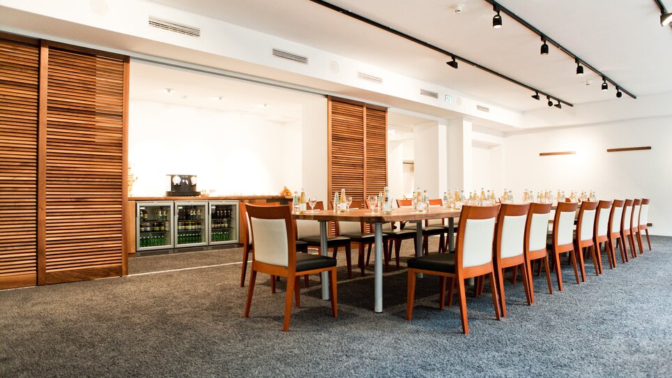 A meeting room in Grand Hôtel Wiesler, set up for a conference with tables and chairs. | © Florian Weitzer Hotels & Restaurants