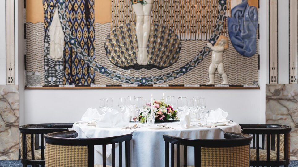 Elegantly set table at Grand Hôtel Wiesler, featuring artwork in the background. | © Florian Weitzer Hotels & Restaurants