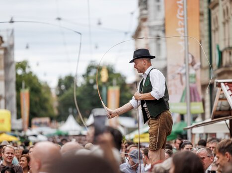 A tightrope walker entertains the crowd at a traditional festival. | © Erwin Scheriau