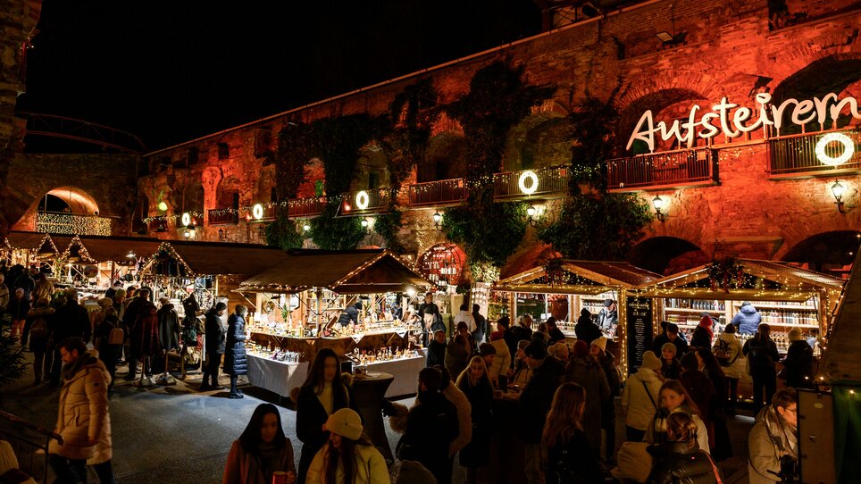 Belebter Weihnachtsmarkt mit festlicher Beleuchtung in Graz. | © Ulrike Rauch
