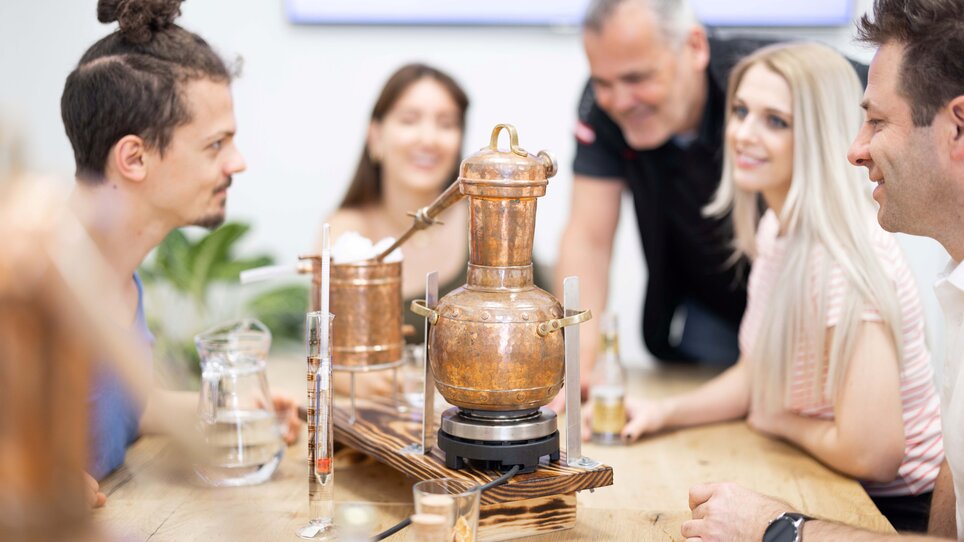 Gruppe genießt die Gin Destillation im Konferenzraum. | © Retter Events