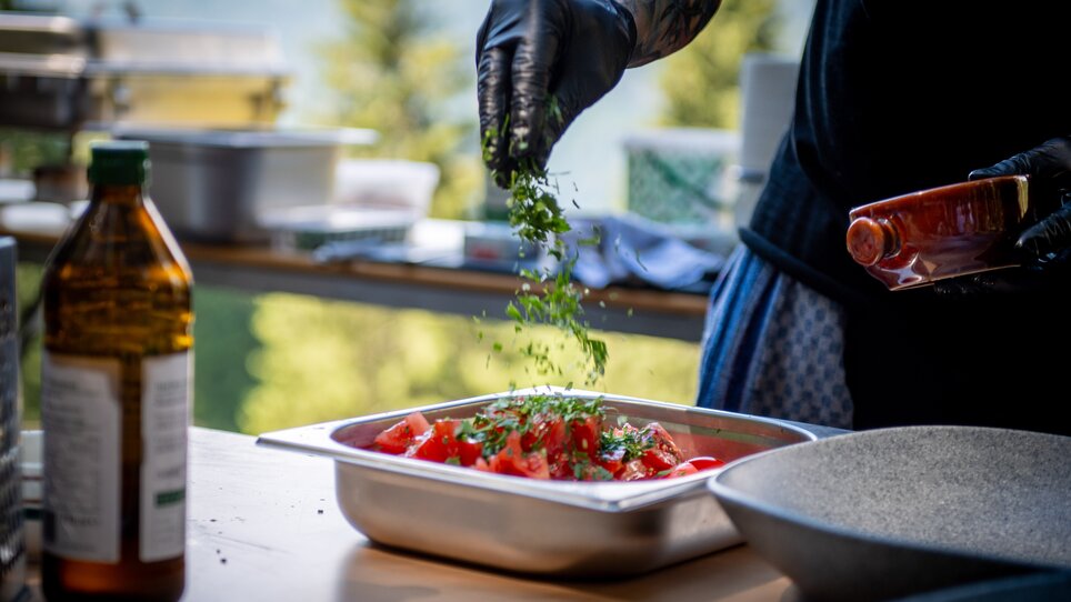 Fresh tomatoes and herbs are being prepared in the Underground Kitchen. A professional kitchen with high-quality equipment. | © Alex Rauch
