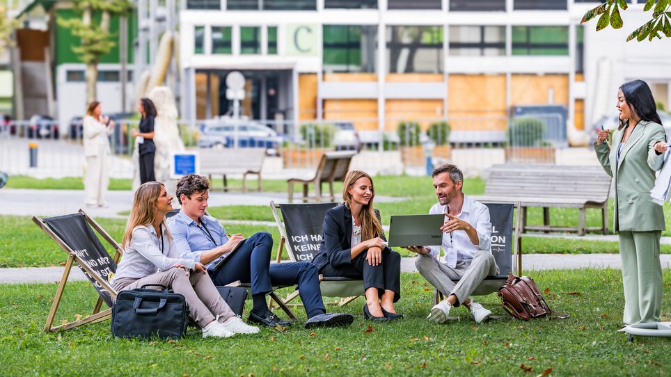Four individuals in a business meeting outdoors in Graz, emphasizing collaboration. | © Graz Tourismus - Mias Photoart