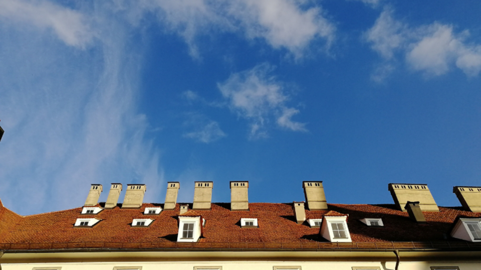 Foto Haus mit heller Fassade und vielen Schornsteinen vor blauem Himmel | © Ruth Nezmahen