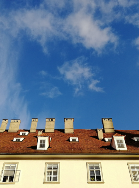 Foto Haus mit heller Fassade und vielen Schornsteinen vor blauem Himmel | © Ruth Nezmahen