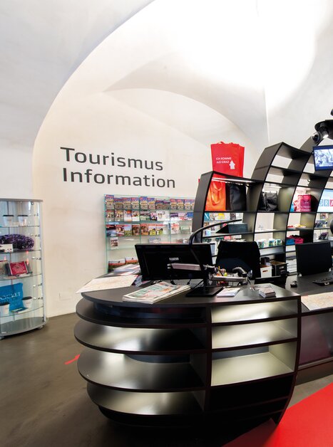 Moderne Touristinformation mit schwarzer Empfangstheke und Informationen. | © Graz Tourismus - Harry Schiffer