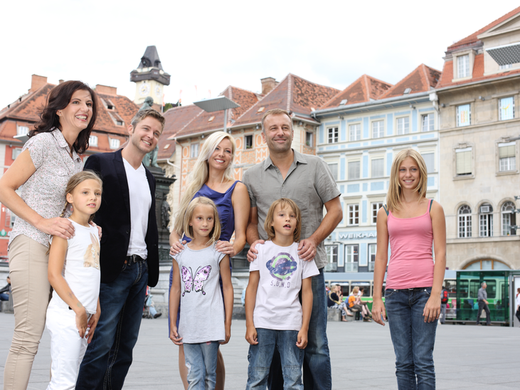 Una famiglia posa di fronte alla Torre dell'Orologio di Graz | © Graz Tourismus - Harry Schiffer