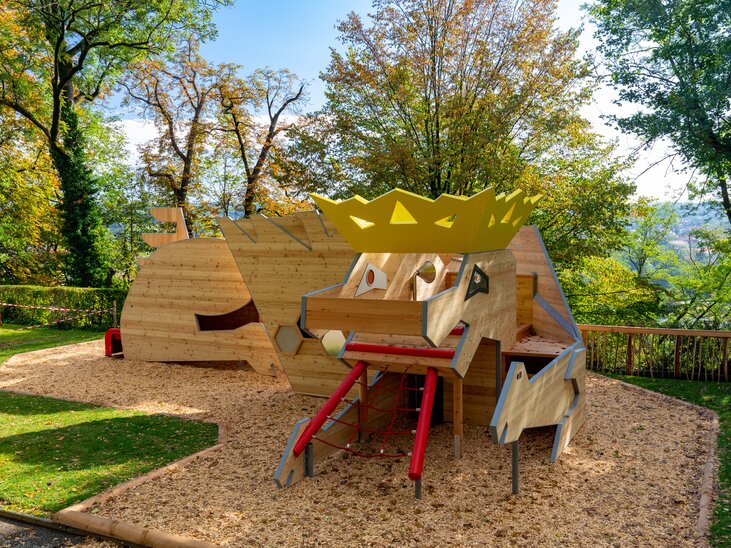 Ein kreatives Spielgerät in einem Park, umgeben von Bäumen und Holzschnitzeln. | © Graz Tourismus - Harry Schiffer