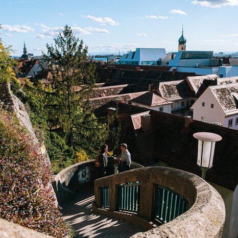 Blick auf Graz vom Schlossbergsteig mit Stadthäusern und schöner Dachlandschaft. | © Graz Tourismus
