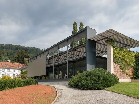 A minimalist glass and steel building in Graz, surrounded by green areas. | © Universalmuseum Joanneum - N. Lackner