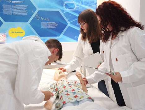 Drei Personen üben an einem medizinischen Übungspuppen im Trainingsraum. | © Universalmuseum Joanneum - J. Kucek