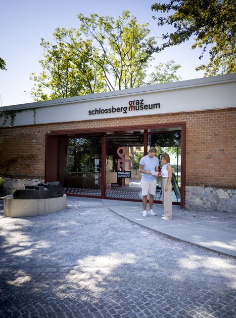 Visitors stand in front of Graz Museum Schlossberg, visible in the background. | © Graz Tourismus - Tom Lamm