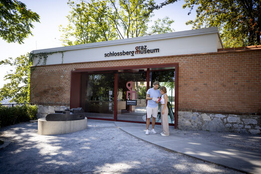 Besucher stehen am Eingang des Graz Museum Schlossberg an einem sonnigen Tag. | © Graz Tourismus - Tom Lamm