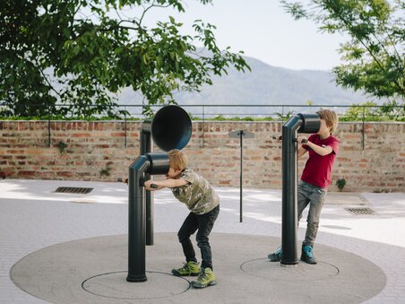 Two boys playing with sound sculptures outdoors, excited by the sounds. | © Sebastian Reiser