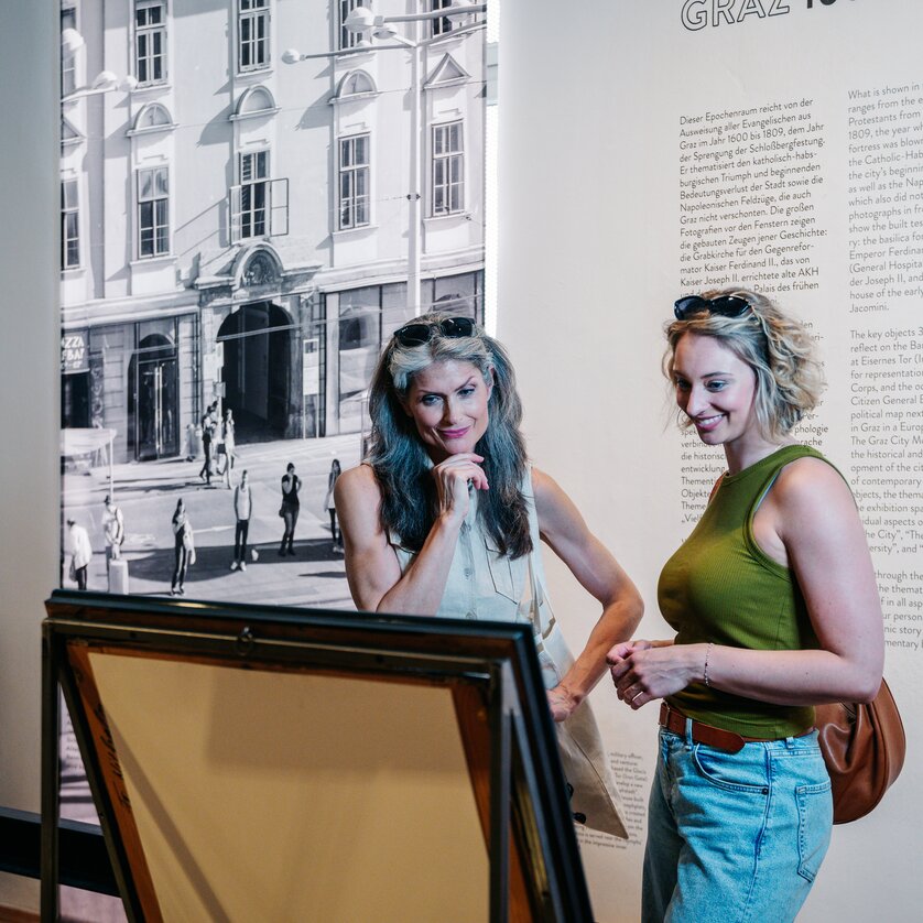 Zwei Frauen betrachten Kunstwerke im Graz Museum. | © Graz Tourismus - Mias Photoart