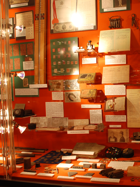 Showcase with various historical objects and documents. | © Hans Gross Kriminalmuseum, Universitätsmuseen der Universität Graz - Manuela Zweytik