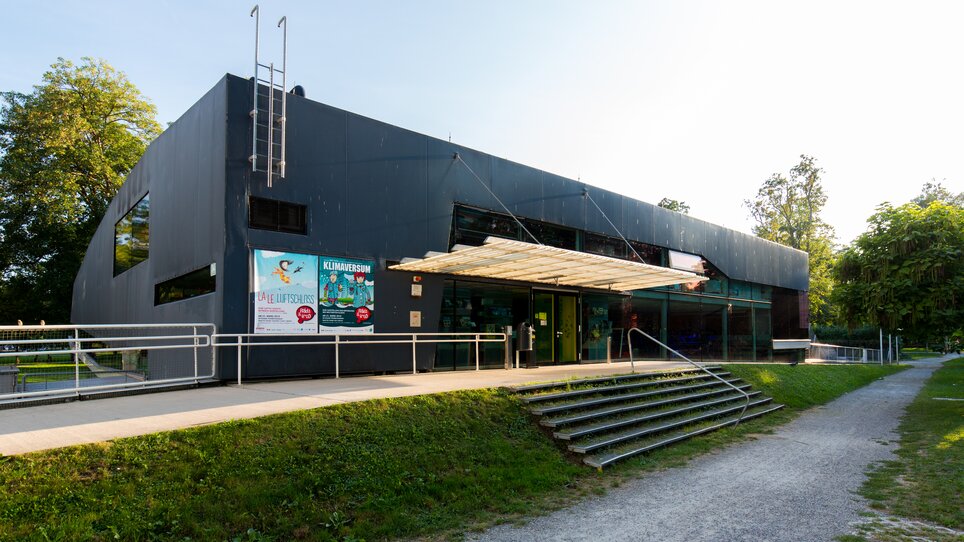 Architektonisches Design eines modernen Gebäudes, mit großen Fenstern und einem überdachten Eingang. | © Graz Tourismus - Harry Schiffer