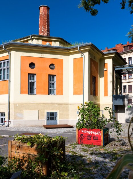 Das Museum der Wahrnehmung in Graz, orangefarbenes Gebäude mit Garten und urbanem Raum. | © Graz Tourismus - Harry Schiffer