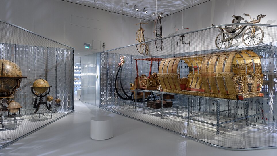 Ausstellungsraum mit historischen Globussen und Wagen. | © UMJ - N. Lackner