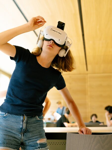 Un bambino indossa un visore VR mentre esplora un ambiente digitale.