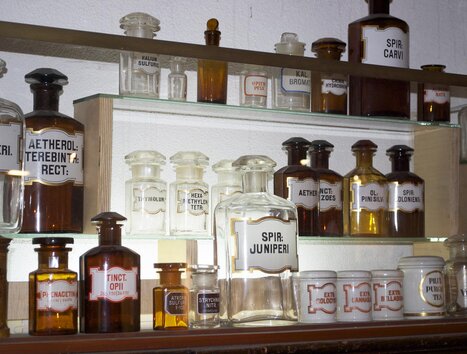 Scaffale con antiche bottiglie di farmacia e etichette. | © Theriak Museum
