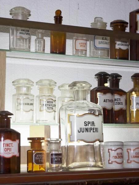 Shelf with vintage apothecary bottles and labels. | © Theriak Museum