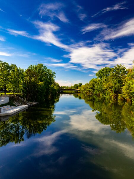 Spiegelnder Fluss in der Augartenbucht in Graz unter blauem Himmel. | © Graz Tourismus - Harry Schiffer